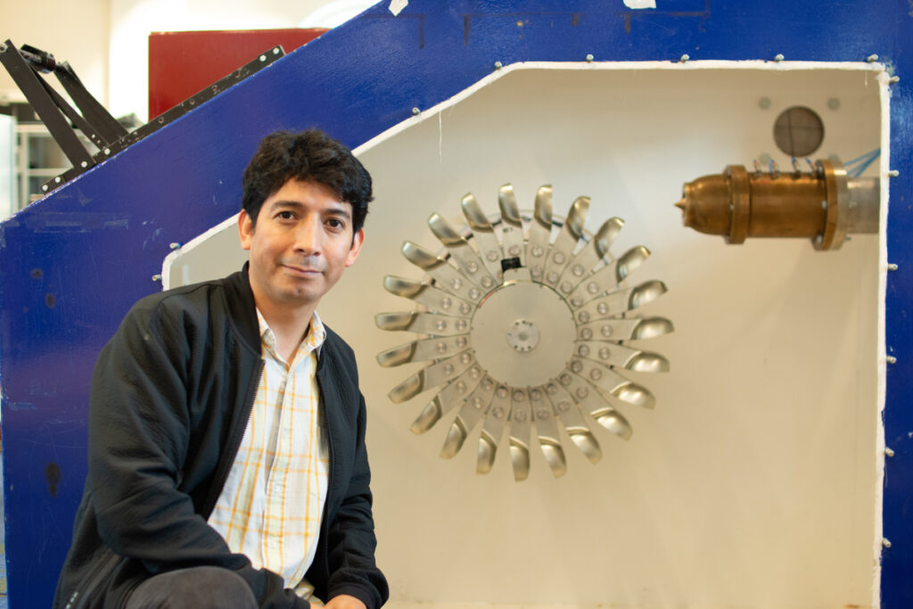 researcher in front of rig with turbine that looks like a sunflower. photo