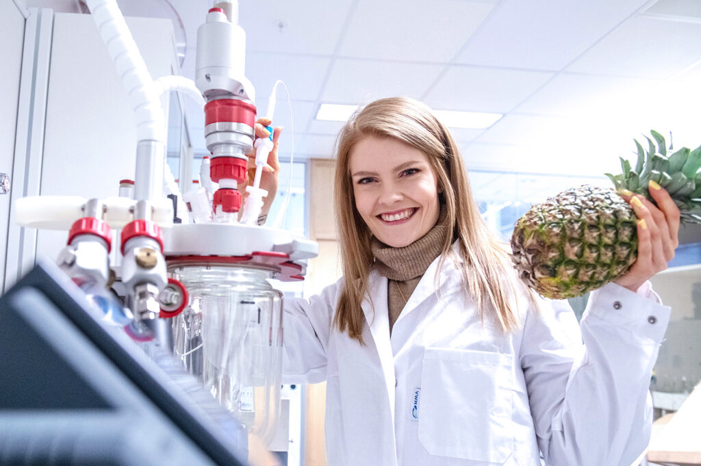 Et bilde av en kvinne på en lab med en ananas.