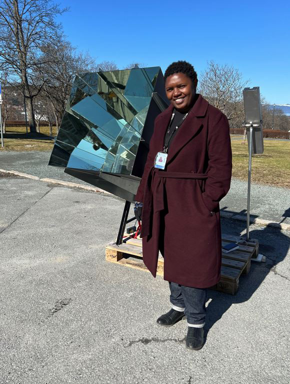 A picture of a woman posing with a solar concentrator.