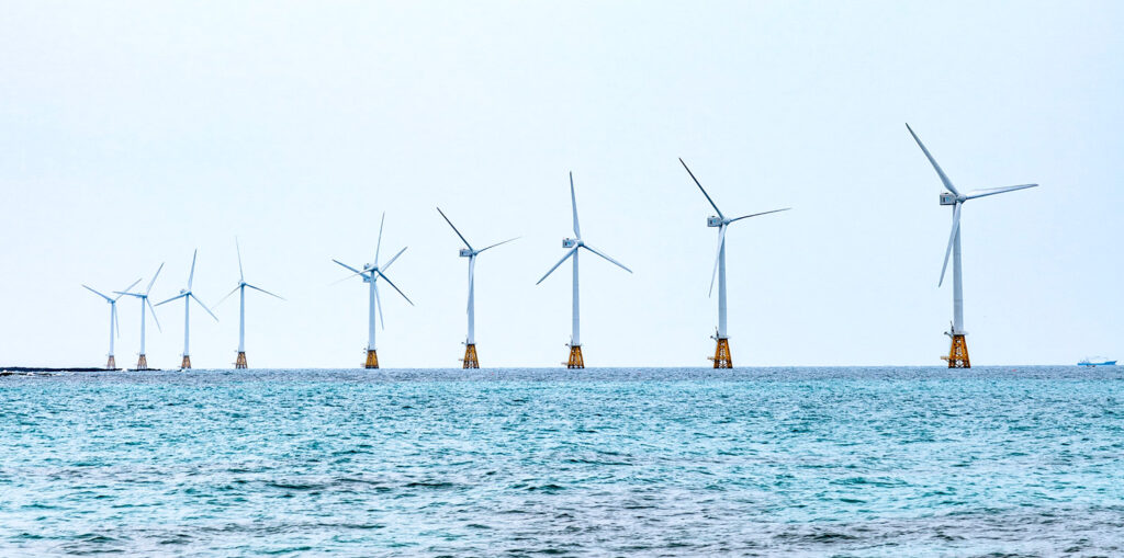 Et bilde av 9 vindmøller på havet.