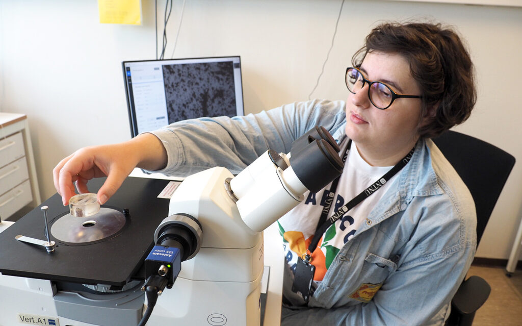 Et bilde av en kvinne som jobber med et mikroskop