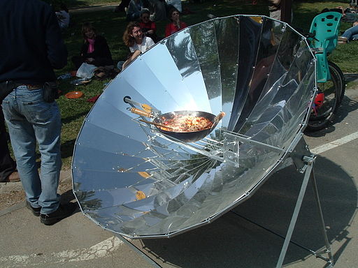 Et bilde av en stekepanne med mat i på en solgrill.
