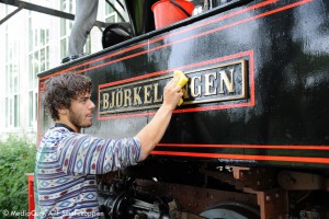 Et bilde av en mann som pusser et tog.