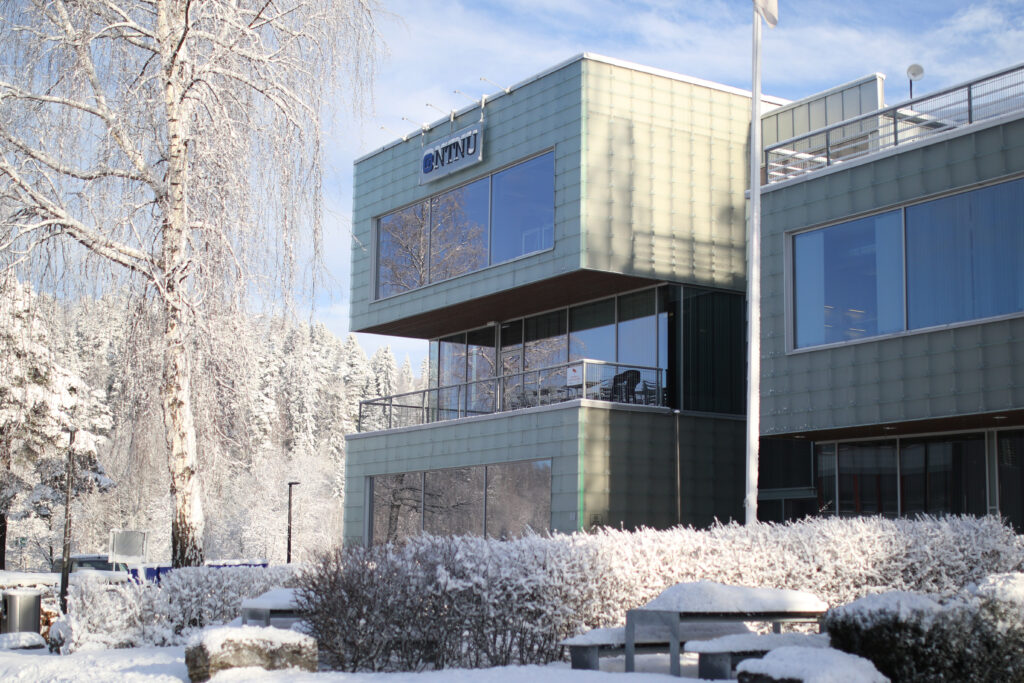 G-bygget på campus Gjøvik. Snø på bakken, i trær og busker.