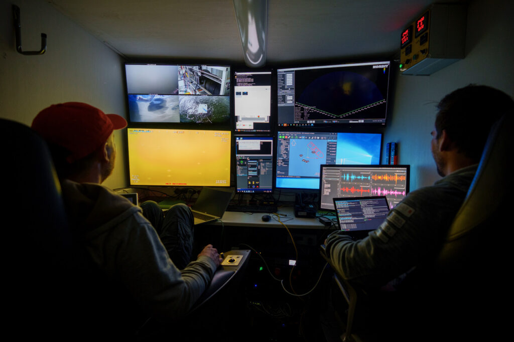 To teknikere i et kontrollrom som styrer undervannsroboter